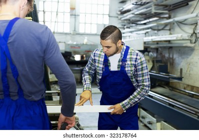 Two  males working on a machine in factory