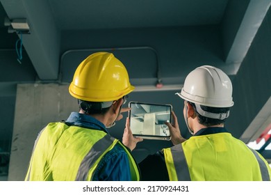 Two Man Civil Engineer and Contractor working in construction site. Team Architect working use BIM technology and digital construction application on digital tablet.