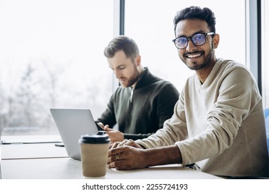 Two man colleagues working at the office on a computer - Shutterstock ID 2255724193
