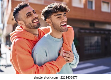 Two man couple hugging each other standing at street - Shutterstock ID 2211433877