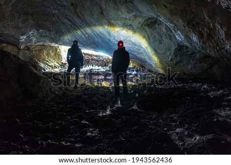 Two man exploring dark cave with light headlamp underground. Cave Ledenjaca in Bosnia and Herzegovina.