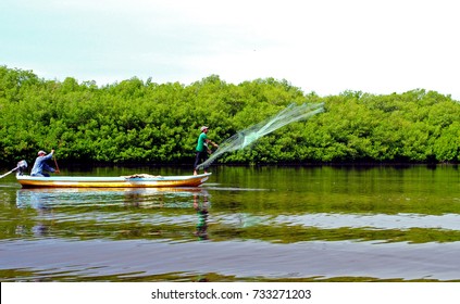 Two Man Fishing On A Boat With Net In The Estuary Of Rural Fishery Community Called La Lupe In Chiapas Mexico