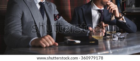 Two man having drinks and cigars