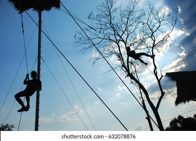 Two Man jumping off the tower and hanging on sling
