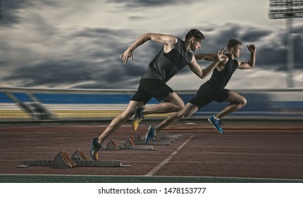 Two Man Sprinter Leaving Starting Blocks On The Athletic Track 