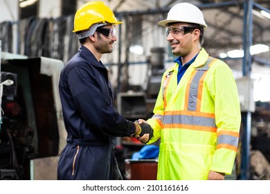 Two Man Worker Hand Shake At Industrial Factory Wearing Uniform And Hard Hats And Mechanical Repair.  Engineer Operating  Lathe Machinery