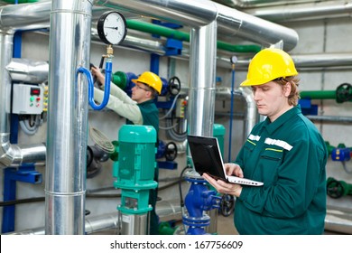 Two man working in a factory, controls the operation of devices in a Heating Plant or Refinery. Please see my other photo and videos with the same theme.