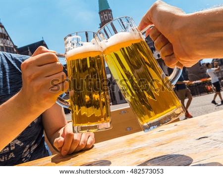 two mans holding beer mug at a beer garden in germany