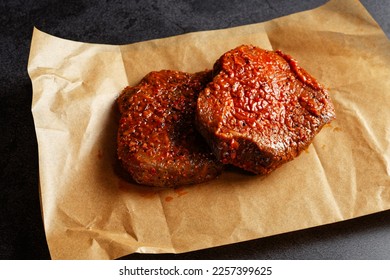 Two marinated beef steaks on a brown wrapping paper
