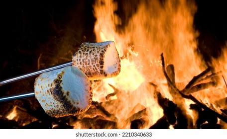 Two Marshmallows Being Roasted To Make Smores Over A Campfire