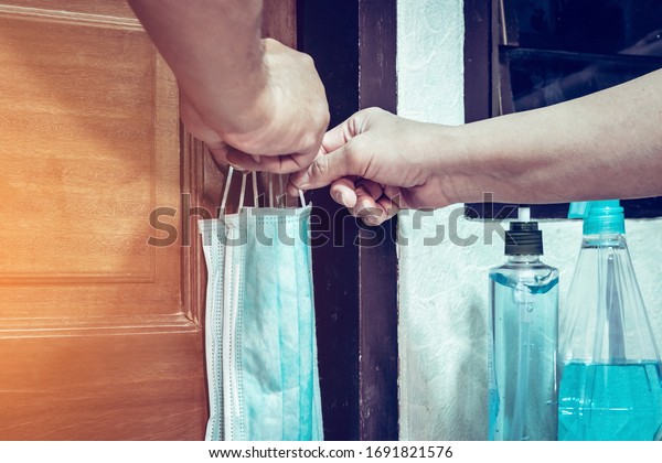 Two masks for lovers\
hanging on the bedroom door knob with alcohol gel to wash hands to\
prevent prevent the spread of germs and avoid infections corona\
virus (Covid-19)