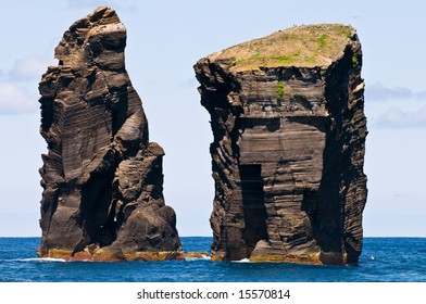 Two massive lava stone pillars raising from the Atlantic