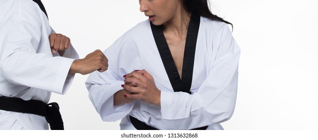 Two Master Black Belt TaeKwonDo Handsome Asian Teacher Man And Caucasian Beautiful Competitor Woman Fighter Show Hit Fighting Pose, Self Defense, Studio Lighting White Background Isolated