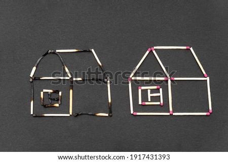 Two match houses made of burnt and unburnt matchsticks on a black background.Creative flat lay composition. Fire insurance coverage concept.