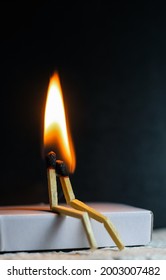 Two matches burning sitting together on the matchbox in the dark copy space. Two matches in flame as a metaphor of togetherness friendship, Love And Romance Concept. Matchstick art photography.