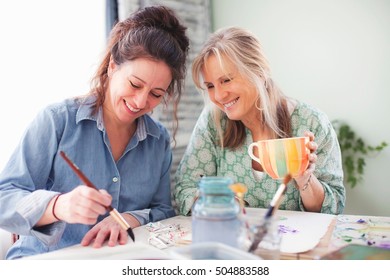 Two Mature Female Artists Painting In Studio