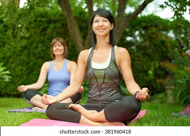 Two Mature Women Keeping Fit By Doing Yoga In The Summer