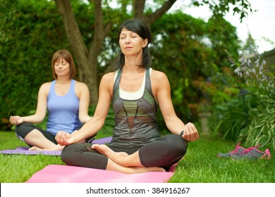 Two Mature Women Keeping Fit By Doing Yoga In The Summer