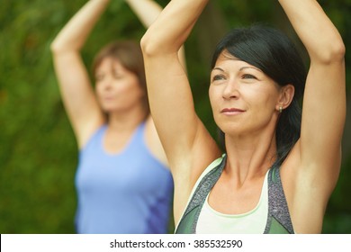 Two Mature Women Keeping Fit By Doing Yoga In The Summer