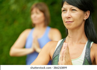 Two Mature Women Keeping Fit By Doing Yoga In The Summer