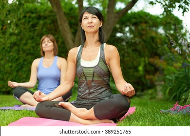 Two Mature Women Keeping Fit By Doing Yoga In The Summer