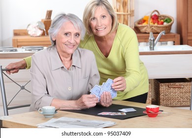 Two mature women playing cards. - Powered by Shutterstock