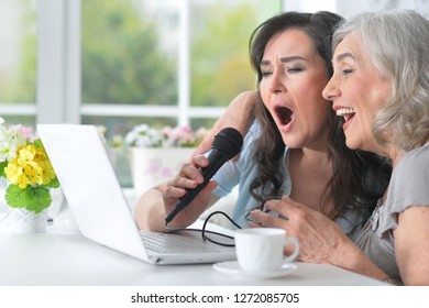 Two Mature Women Singing Karaoke With Laptop