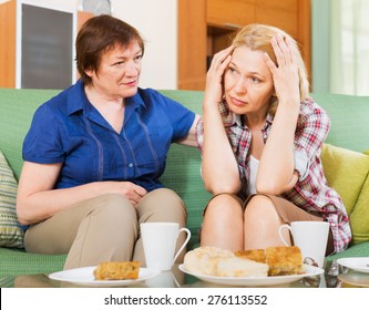 Two Mature Women Sitting At The Table With Tea And Sharing Bad News