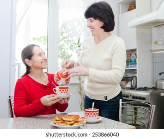 Two Mature Women Talking Over Coffee In   Kitchen.