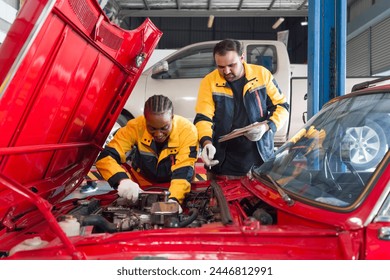 Two mechanic are working on a car with the hood open in an automotive shop or garage. They seem focused and engaged in diagnosing or repairing the vehicle's engine or other component. - Powered by Shutterstock