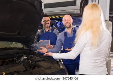 Two Mechanics At A Car Repair Shop Explain The Problem With Anautomobile To An Owner