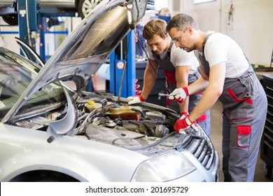 Two Mechanics Fixing Car In A Workshop