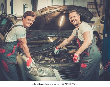 Two Mechanics Fixing Car In A Workshop