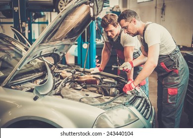 Two Mechanics Fixing Car In A Workshop