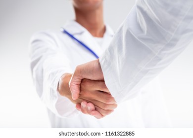 Two Medical Doctors Shaking Hands In Welcome Or Congratulating Each Other After A Successful Patient Outcome