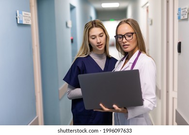 Two medical doctors using notebook computer to discuss patients healh condition