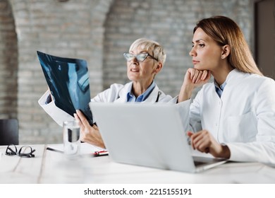  Two medical experts  examining an X-ray image in the office  - Powered by Shutterstock