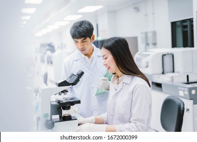 Two  Medical  Scientist Working In Medical Laboratory , Young Female Scientist Looking At Microscope. Select Focus In Young  Female Scientist