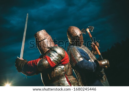 Two Medieval knights armed with axe and sword.