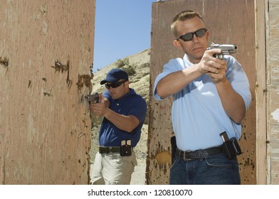 Two men aiming with handgun at combat training