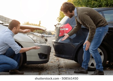 Two men arguing after a car accident on the road