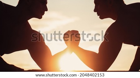 Two men arm wrestling. Silhouette of hands that compete in strength. Rivalry, closeup of male arm wrestling.