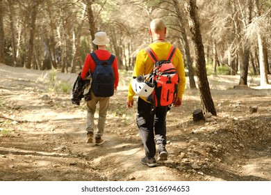 two men with backpacks, backpackers walking along road with magnificent natural scenery, hiking, trekking olive groves, watching nature, concept together travel in Spain, active lifestyle, vacation - Powered by Shutterstock