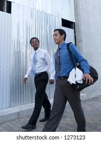 Two men chatting while heading for the gym to work out over lunch.