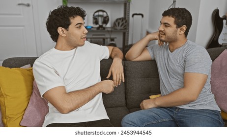 Two men conversing comfortably on a sofa in a modern living room. - Powered by Shutterstock