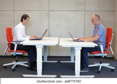 two men coworking in correct sitting posture on chairs in office
