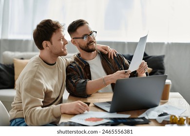 Two men in a designer workshop, working together on a laptop. - Powered by Shutterstock