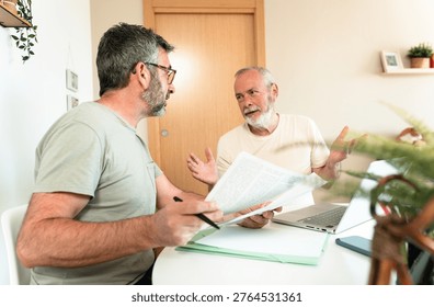 Two men discussing important documents and legal matters during a consultation, addressing paperwork and financial advice at home