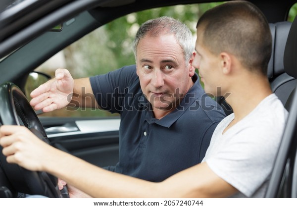 two men discussing work in a\
car