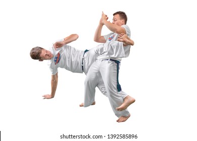 Two men do the fighting element of capoeira. A couple of fighters train capoeira isolated on white background - concept about people, lifestyle and sport. 